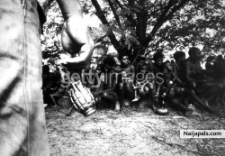 A federal soldier swings a hand grenade by its release pin while guarding Igbo women prisoners and their children in Nigeria, during the Biafran War