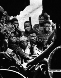 A figure in religious attire at the doorway of a building full of African children during the civil war in Biafra (now part of Nigeria), 1969.