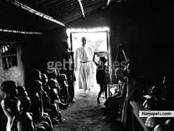 A figure in religious attire at the doorway of a building full of African children during the civil war in Biafra (now part of Nigeria), 1969.