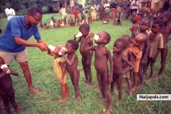 A Biafran doctor hands out cups containing the daily ration of powdered milk to a line of children at a refugee camp in Anwa, Biafra, Aug. 5, 1968.