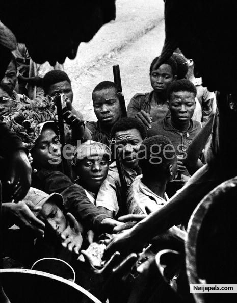 A figure in religious attire at the doorway of a building full of African children during the civil war in Biafra (now part of Nigeria), 1969. - click for next photo