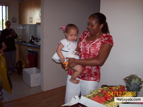 me and amara cutting her 1st b/day cake! not a happy camper... - click for next photo