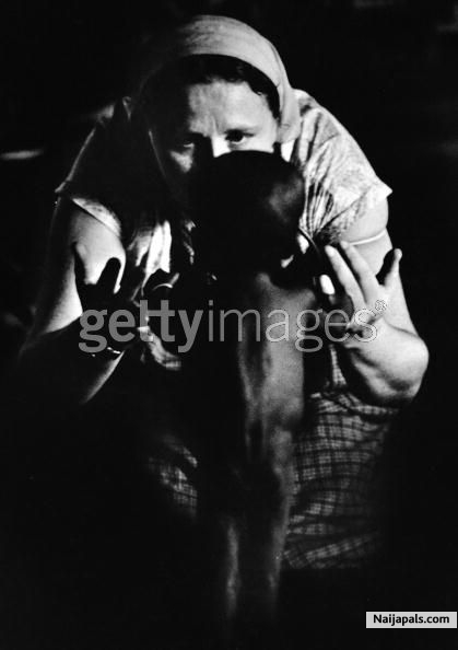 A white carer with a Biafran child holding onto her fingers during the civil war in Biafra (now part of Nigeria), 1969 - click for next photo