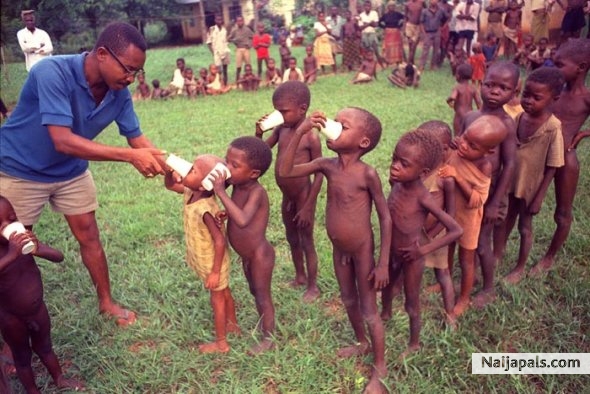 A Biafran doctor hands out cups containing the daily ration of powdered milk to a line of children at a refugee camp in Anwa, Biafra, Aug. 5, 1968. - click for next photo
